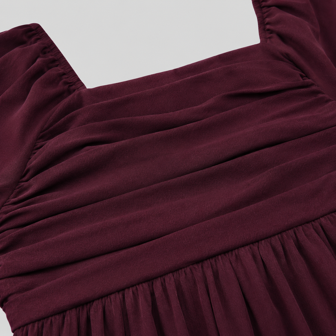 Long sleeve mini dress with square neckline, pleated bodice, defined waist, and flowy fit-and-flare silhouette