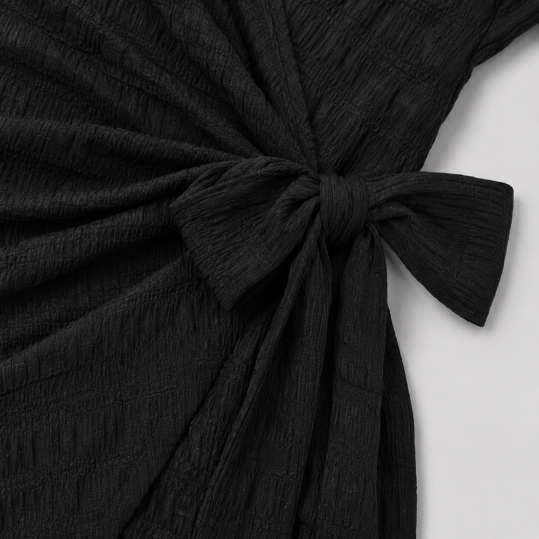 Short sleeve wrap mini dress with surplice V-neckline, side tie waist, and textured fabric