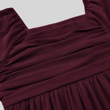 Long sleeve mini dress with square neckline, pleated bodice, defined waist, and flowy fit-and-flare silhouette