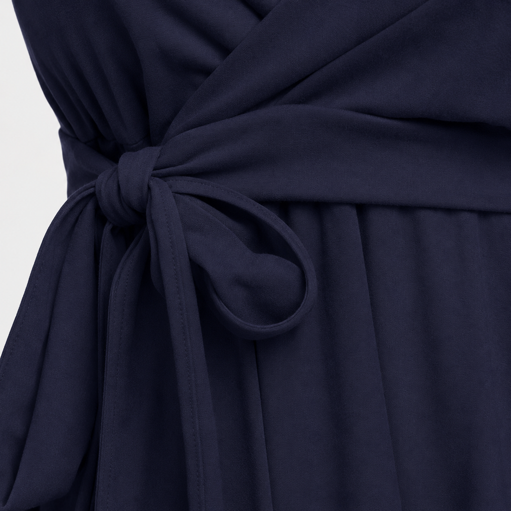 Sleeveless wrap-front peplum cami top with spaghetti straps and adjustable waist tie, styled for elegant everyday wear