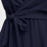 Sleeveless wrap-front peplum cami top with spaghetti straps and adjustable waist tie, styled for elegant everyday wear