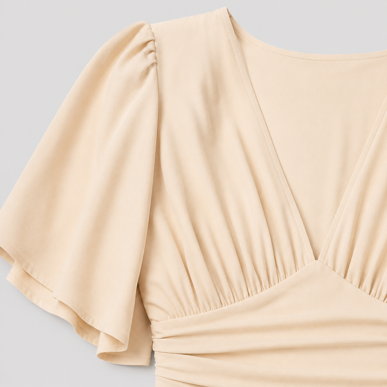 Flutter sleeve mini dress with deep V-neckline, gathered bodice, defined waistband, and fit-and-flare silhouette