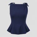 Sleeveless peplum top with boat neckline, shoulder tie accents, sculpted seams, and tailored waist for an elegant structured silhouette