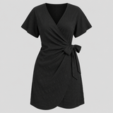Short sleeve wrap mini dress with surplice V-neckline, side tie waist, and textured fabric