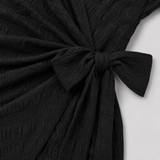 Short sleeve wrap mini dress with surplice V-neckline, side tie waist, and textured fabric