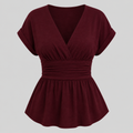 Cap sleeve peplum blouse with surplice V-neckline, wide cinched waistband, and flowy hem for an elegant flattering fit