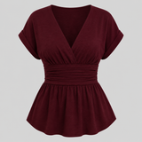 Cap sleeve peplum blouse with surplice V-neckline, wide cinched waistband, and flowy hem for an elegant flattering fit
